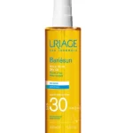 Uriage Bariésun huile sèche SPF 30 en flacon spray de 200ml, haute protection solaire nourrissante et sublimatrice pour le corps et les cheveux.